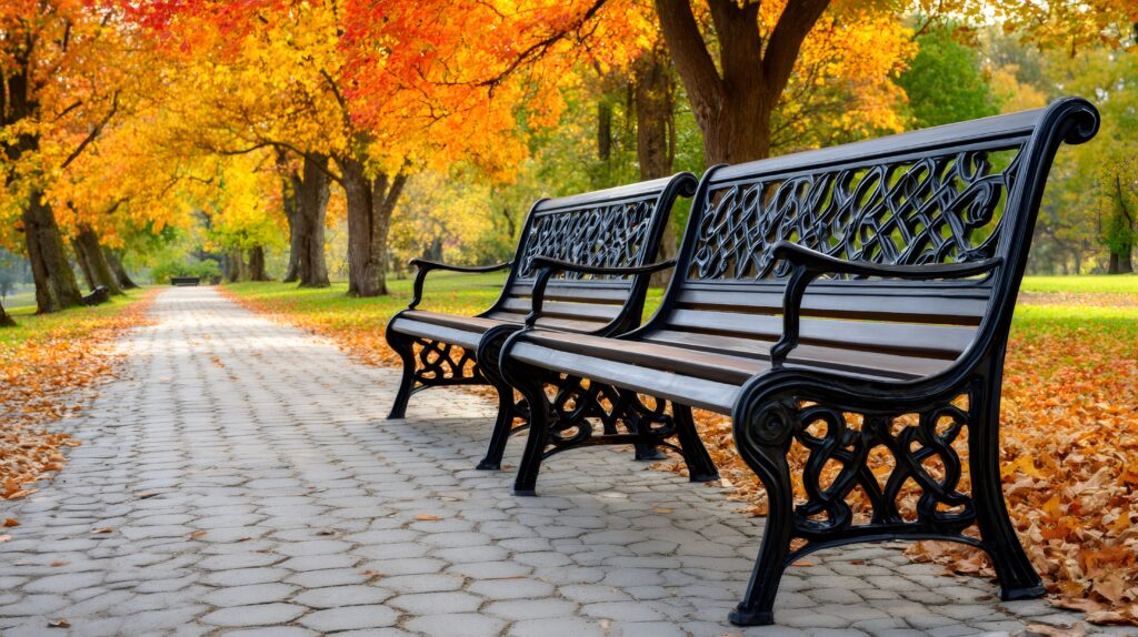 Two benches in a fall setting with leaves on the ground