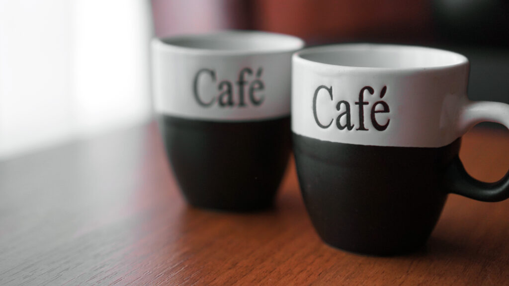 Two coffee cups on a wooden table