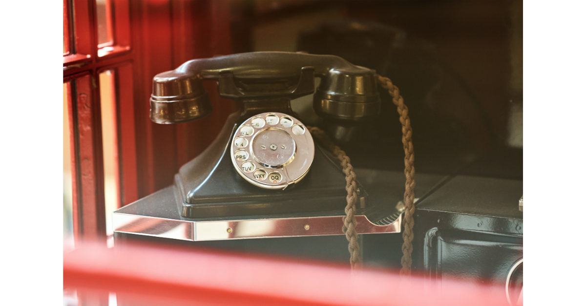 vintage 1940s black rotary phone with red background used for cold calling